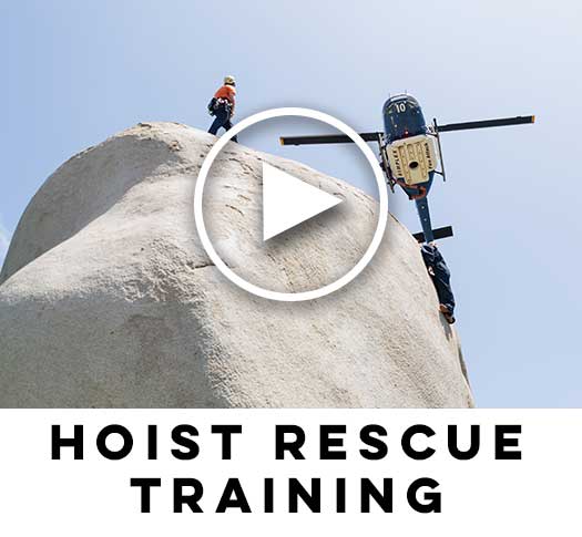 Hoist Rescue training with Search and rescue on hoist on boulder wiith helicopter flying.