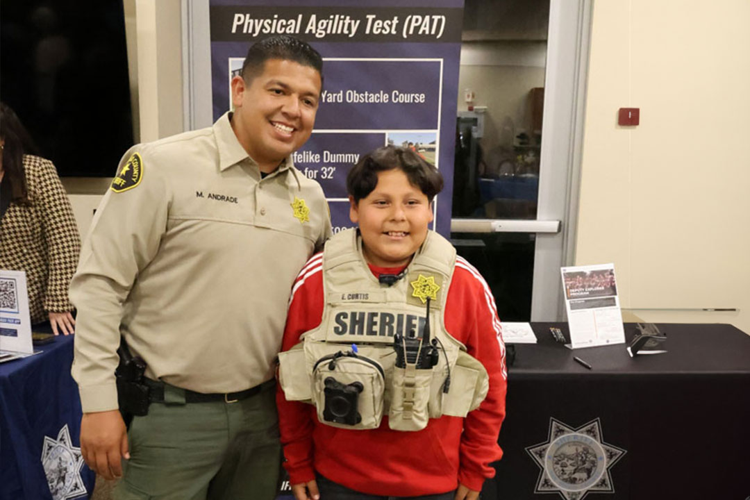 Deputy with a student wearing a sheriff vest.