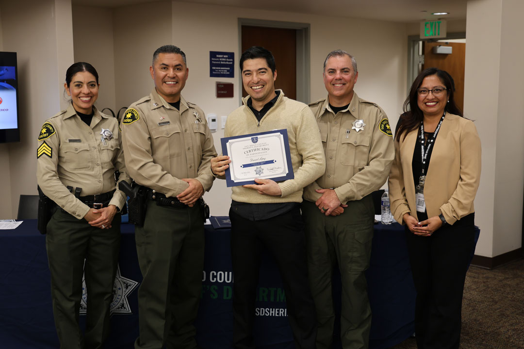 Deputies and a student holding a certificate