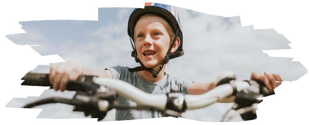 Happy child wearing a helmet riding a bike.