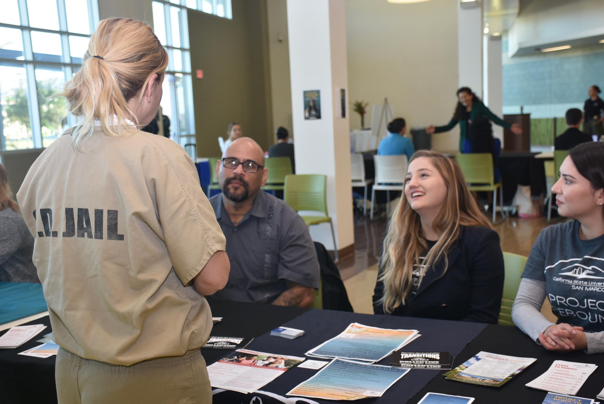 Woman talking to three people at a resource fair