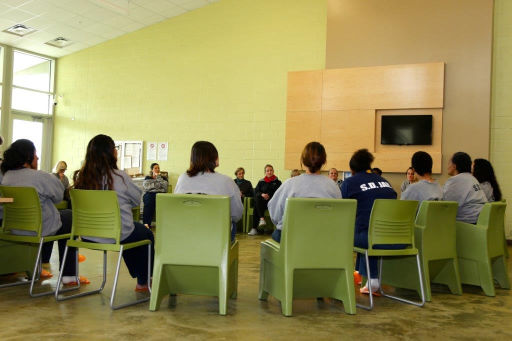 Women sitting in green chair in a circle